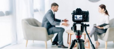selective focus of digital camera shooting journalist and businessman  clipart