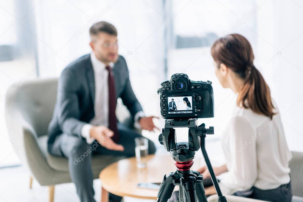 selective focus of digital camera shooting journalist and businessman 