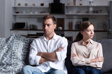 çapraz kolları ile kanepede oturan pensive üzgün adam ve kadın