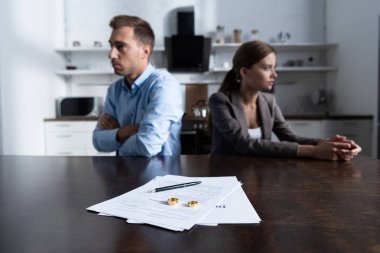 selective focus of couple sitting at table with divorce documents clipart