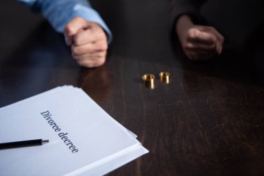 boşanma belgeleri ve yüzükler ile masada çift kısmi görünümü