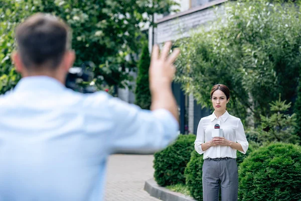 Selektiv Fokus Attraktive Journalist Holder Mikrofon Kameramand Skyde Hende Udenfor - Stock-foto