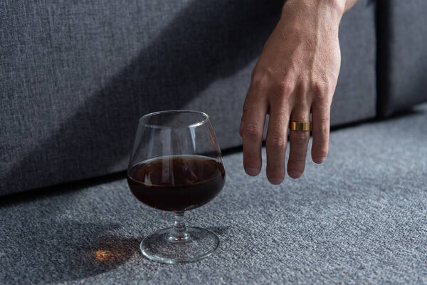 partial view of man with ring and glass of cognac
