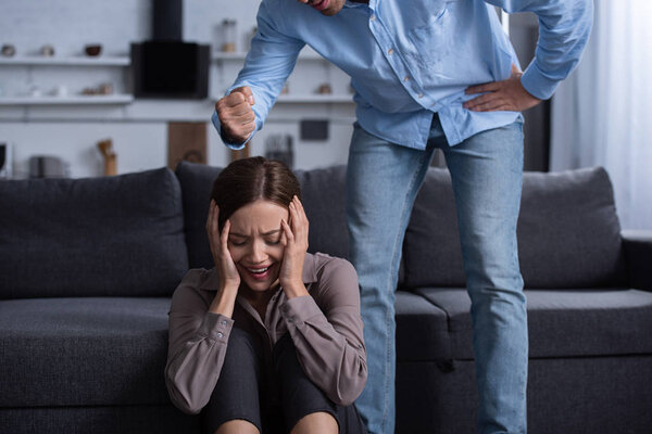 partial view of man beating scared wife during quarrel