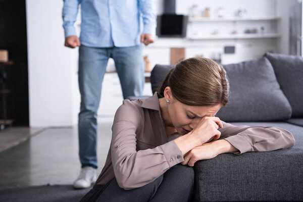 partial view of man and upset crying woman at home
