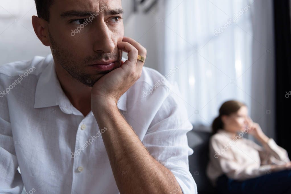 pensive sad man with ring and wife on sofa