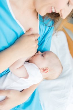 hastanede bebeğini emziren annenin kırpılmış görünümü 