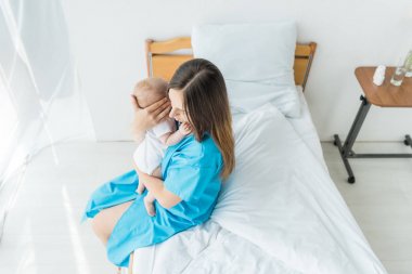 hastanede çocuğunu tutan çekici ve genç anne yüksek açı görünümü 