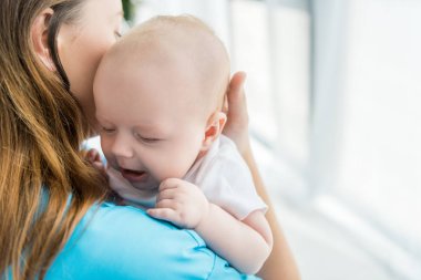 hastanede çocuğunu tutan genç anne kırpılmış görünümü 