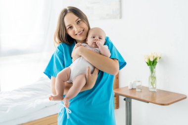 hastanede çocuğunu tutan çekici ve genç anne 