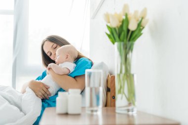 hastanede çocuğunu tutan çekici ve genç anne 