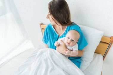 hastanede çocuğunu tutan çekici ve genç anne 