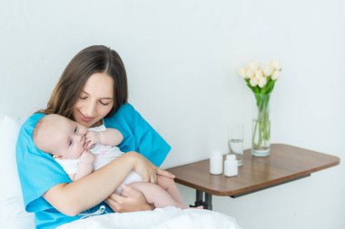 hastanede çocuğunu tutan çekici ve genç anne 