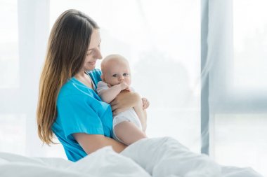 hastanede çocuğunu tutan çekici ve genç anne 