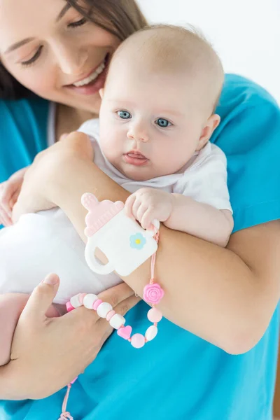 Atractiva Sonriente Madre Sosteniendo Hijo Con Juguete Hospital — Foto de Stock