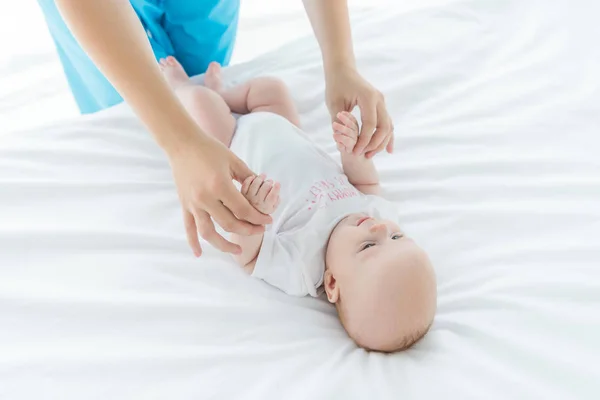 病院でかわいい赤ちゃんの手を握っている母親のトリミングビュー — ストック写真