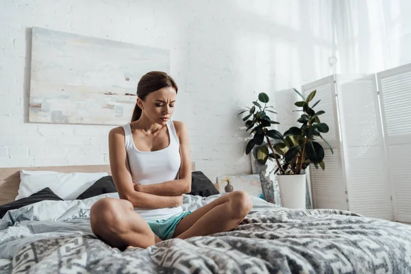 Triste Jovem Mulher Sentada Cama Tocando Barriga — Fotografia de Stock