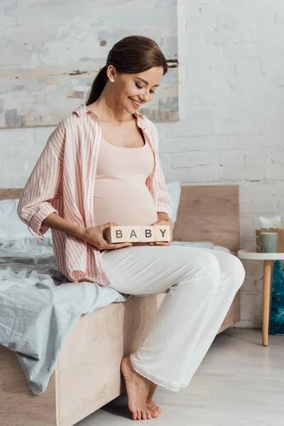 Lachende Zwangere Vrouw Holding Houten Blokken Met Word Baby — Stockfoto