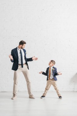 boutonnieres birbirlerine bakarak ceketli baba ve oğul tam uzunlukta görünümü