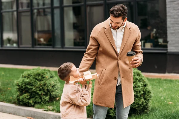 Sonriente Padre Sosteniendo Taza Café Desechable Hijo Con Avión Juguete — Foto de Stock