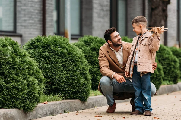 Bärtiger Vater Und Lächelnder Sohn Mit Spielzeugflugzeug Schauen Sich Auf — Stockfoto