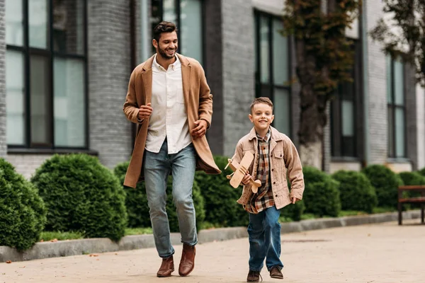 Pleine Longueur Vue Papa Manteau Fils Avec Jouet Avion Courir — Photo