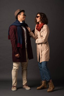 siyah arka plan üzerinde birbirlerine bakarak sonbahar kıyafeti mutlu şık ırklararası çift