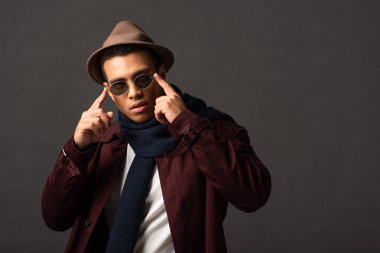 siyah arka plan üzerinde eşarp, güneş gözlüğü ve şapka zarif karışık Yarış adam