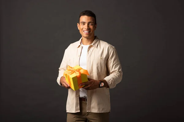 Smiling Handsome Mixed Race Man Beige Shirt Holding Present Black — Stock Photo, Image