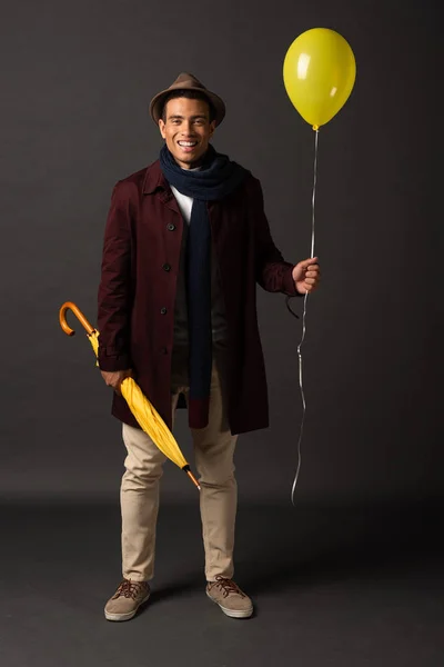 Smiling Mixed Race Man Scarf Hat Holding Yellow Balloon Umbrella — Stock Photo, Image