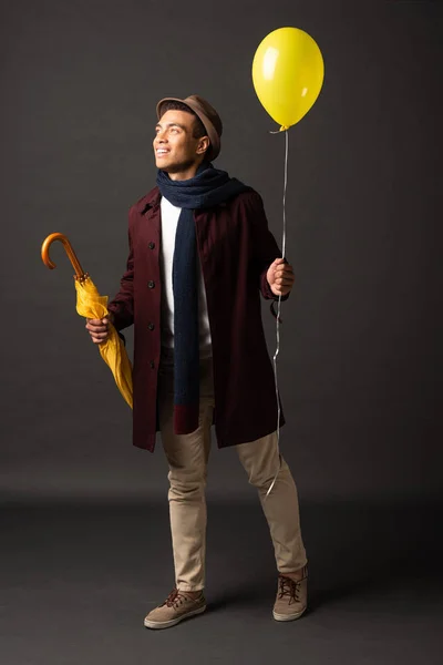 Smiling Mixed Race Man Scarf Hat Holding Yellow Balloon Umbrella — Stock Photo, Image