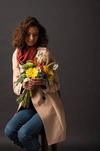 Curly Woman Trench Coat Holding Bouquet Autumnal Wildflowers Black Background — Stock Photo, Image