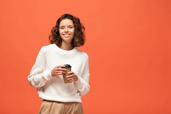 微笑的女人拿着咖啡去隔离在橙色 — 图库照片