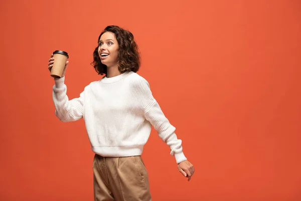 快乐的女人拿着咖啡去隔离在橙色 — 图库照片