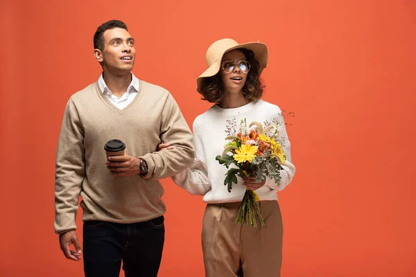 Shocked Interracial Couple Autumn Outfit Coffee Bouquet Flowers Isolated Orange — Stock Photo, Image