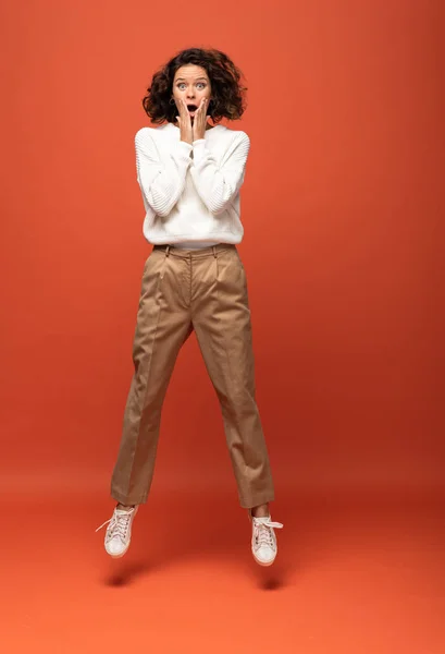 Shocked Curly Woman Jumping Orange Background — Stock Photo, Image