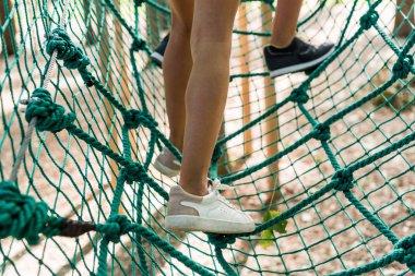 cropped view of kids standing on high rope trail  clipart
