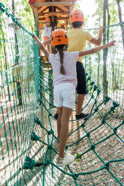 back view of kids standing on high rope trail  clipart