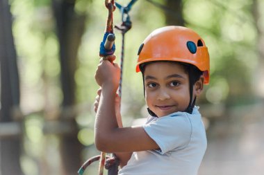 Turuncu kasklı Afro-Amerikan çocuk macera parkında 