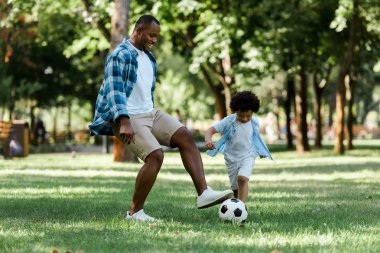 kıvırcık oğlu ile futbol oynayan mutlu afrikalı-amerikalı adam 