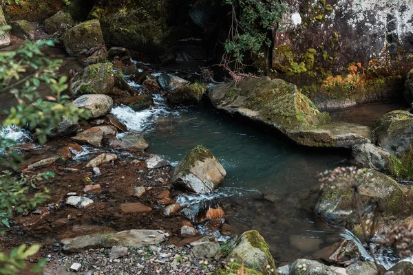 selective focus of flowing water near wet stones  
