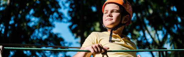 panoramic shot of cute boy in orange helmet outside 