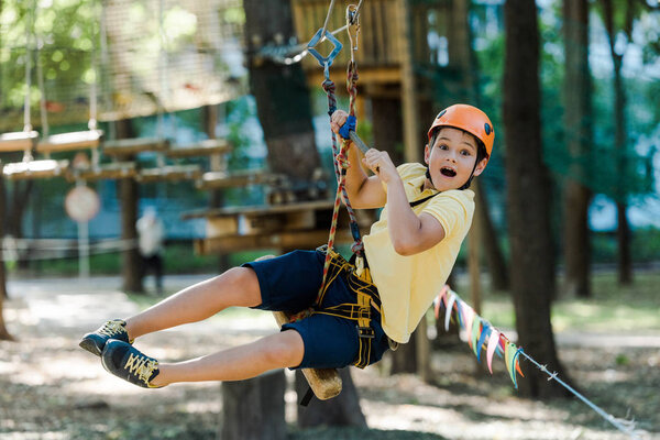 surprised kid in helmet riding in adventure park 