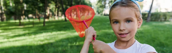 外で蝶のネットを持っている幸せな子供のパノラマショット — ストック写真