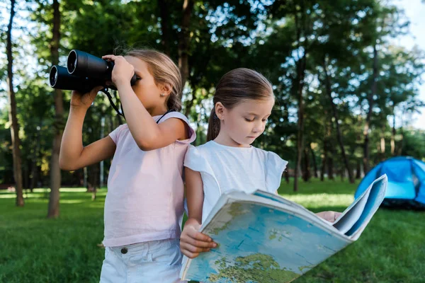 Lindo Niño Sosteniendo Mapa Cerca Amigo Mirando Través Binoculares —  Fotos de Stock