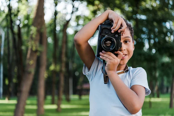 Симпатичный Африканский Мальчик Держит Цифровую Камеру Время Фотографирования Парке — стоковое фото