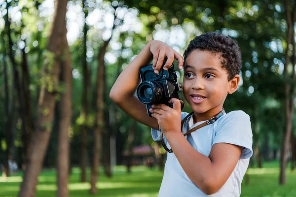 Bonito Africano Americano Menino Segurando Câmera Digital Parque — Fotografia de Stock