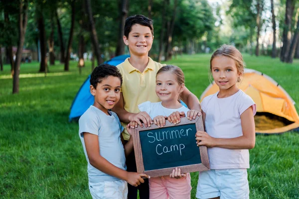 Niños Multiculturales Felices Sosteniendo Pizarra Con Letras Campamento Verano — Foto de Stock