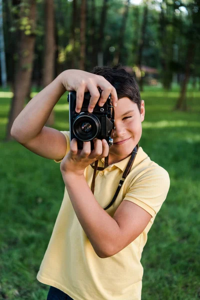 ポジティブな男の子がデジタルカメラを持ちながら — ストック写真