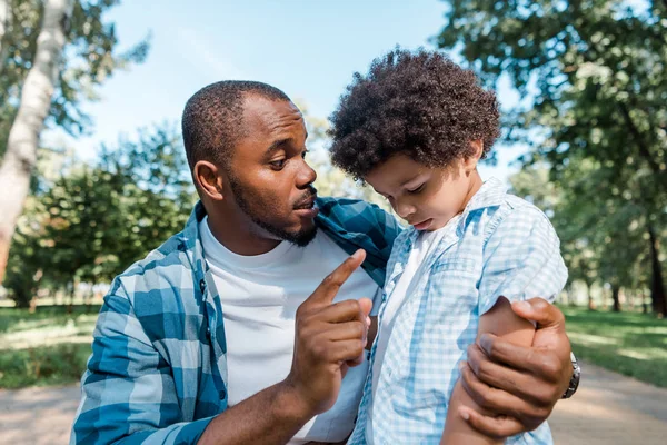 Bonito Pai Olhando Para Afro Americano Triste Filho Enquanto Apontando — Fotografia de Stock